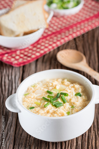 Egg drop soup in white bowl.