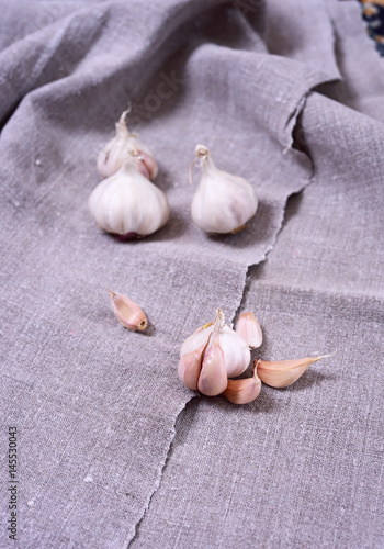 White garlic in husk on gray fabric