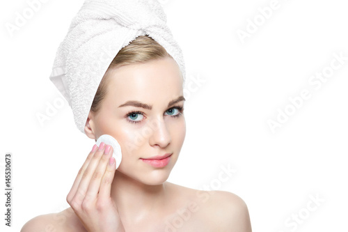 Fotografia Young blond woman with towel in her hair removing make up