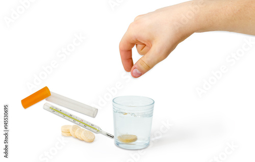 Effervescent tablet thrown into glass of water and clinical thermometer