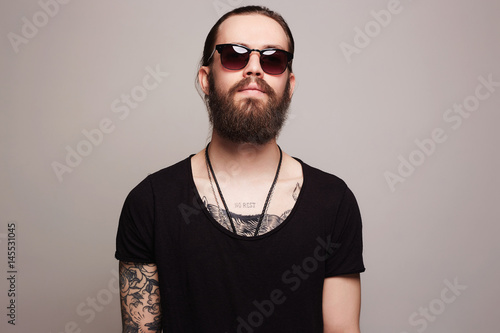 fashionable handsome man with tattoo and sunglasses