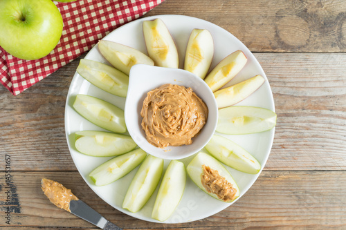 Green apple sliced with peanut butter. Top view.