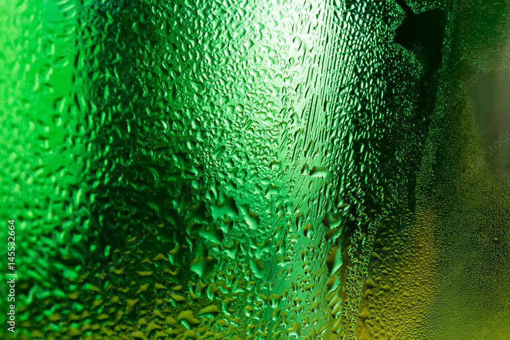 Water condensed on green glass surface background.