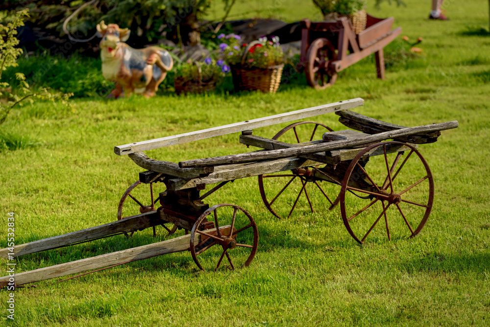 Old cart as a decorative element on a green lawn.