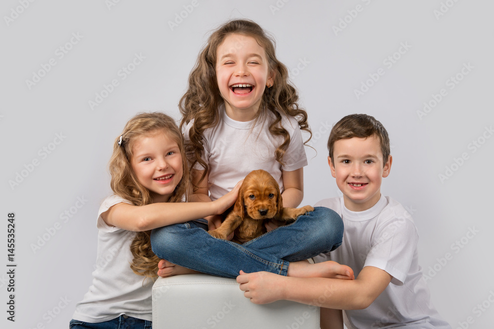 Kids pet friendship concept - children holding red puppy isolated on white background
