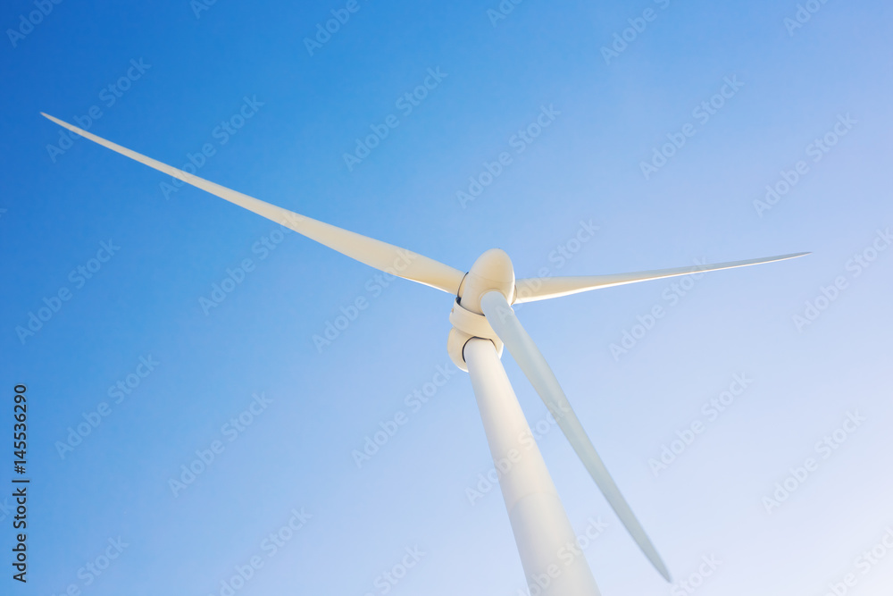 Wind turbine generating electricity with blue sky - energy conservation concept Wind turbine generating electricity with blue sky - energy conservation concept