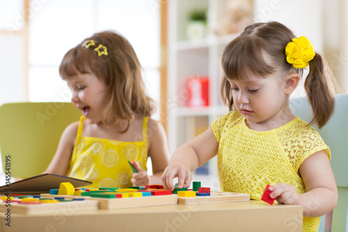 Preschool children playing with educational sorter toys in classroom  kindergarten or home