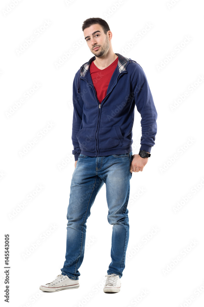 Friendly young handsome guy in blue sweatshirt looking at camera. Full body length portrait isolated over white studio background. Friendly young handsome guy in blue sweatshirt looking at camera. Full body length portrait isolated over white studio background.