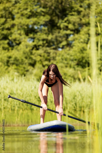 Stand up paddle board woman paddleboarding on SUP © Piotr Marcinski