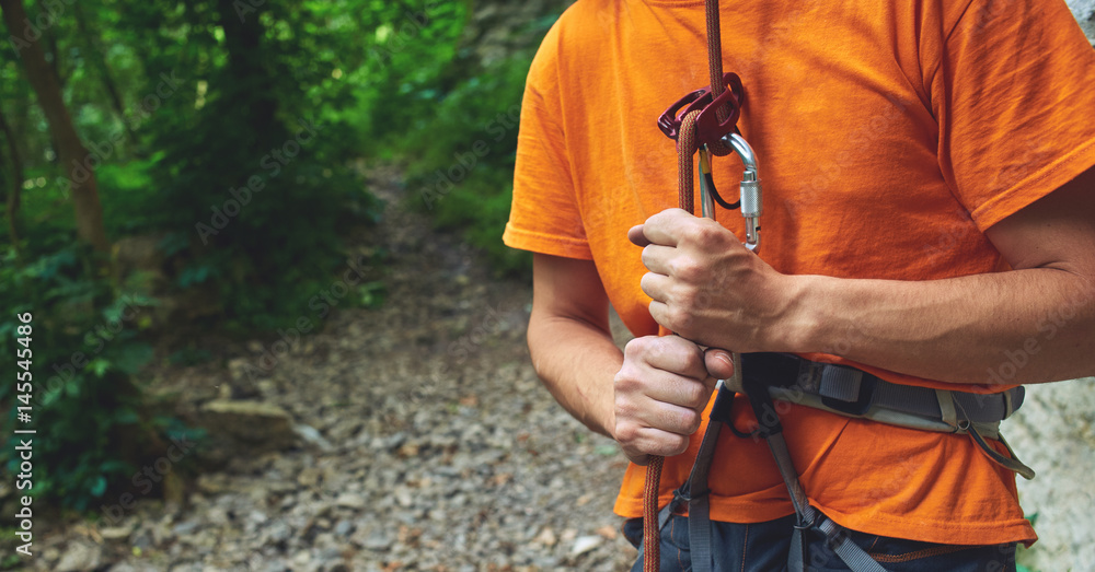 Foto A man insures climber through a belay device