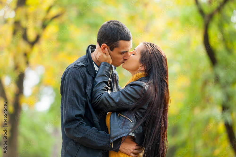 Fototapeta premium photo of cute couple kissing on the wonderful autumn park background