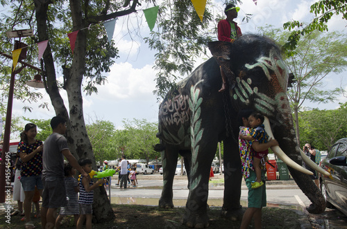 Thai people and foreigner travelers playing and splashing water with elephants and people in Songkran Festival at Ayutthaya