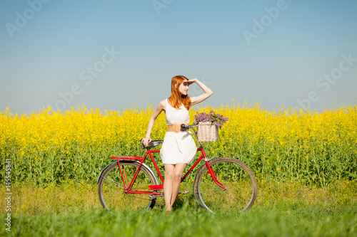 Fototapeta Naklejka Na Ścianę i Meble -  photo of beautiful young woman with bicycle on the wonderful flower field background