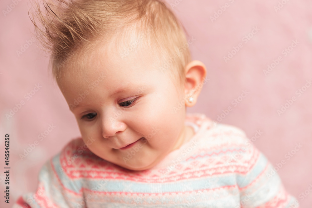 smiling little baby girl looks down to side smiling little baby girl looks down to side