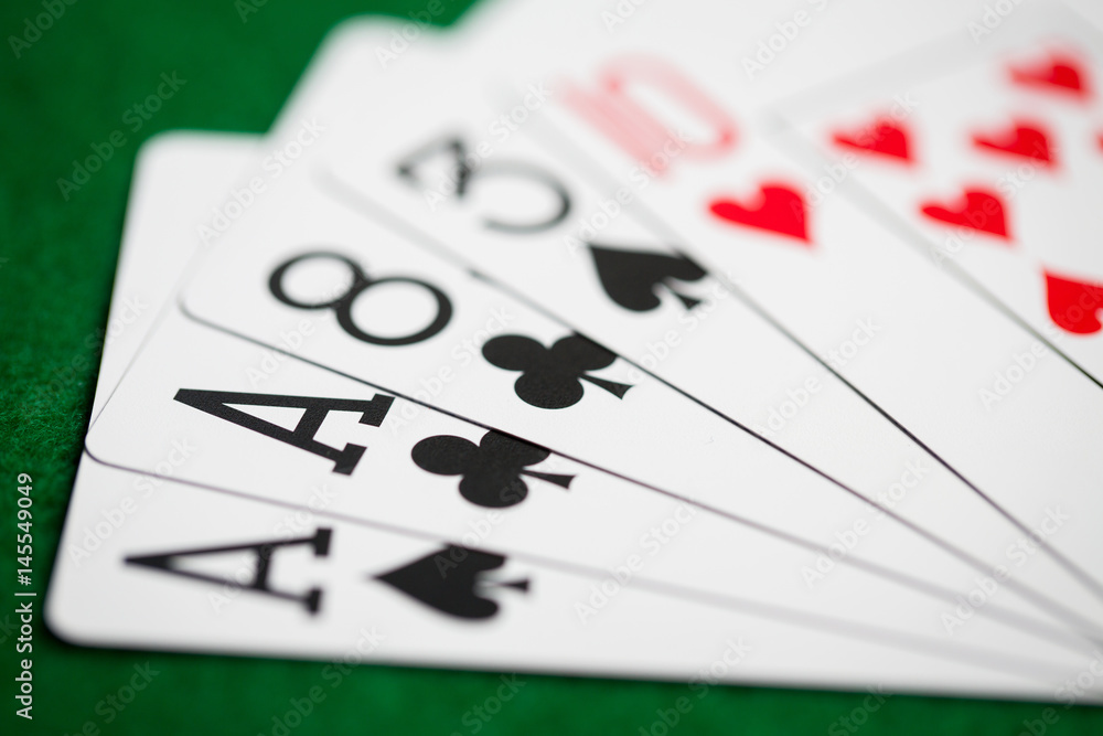 poker hand of playing cards on green casino cloth poker hand of playing cards on green casino cloth