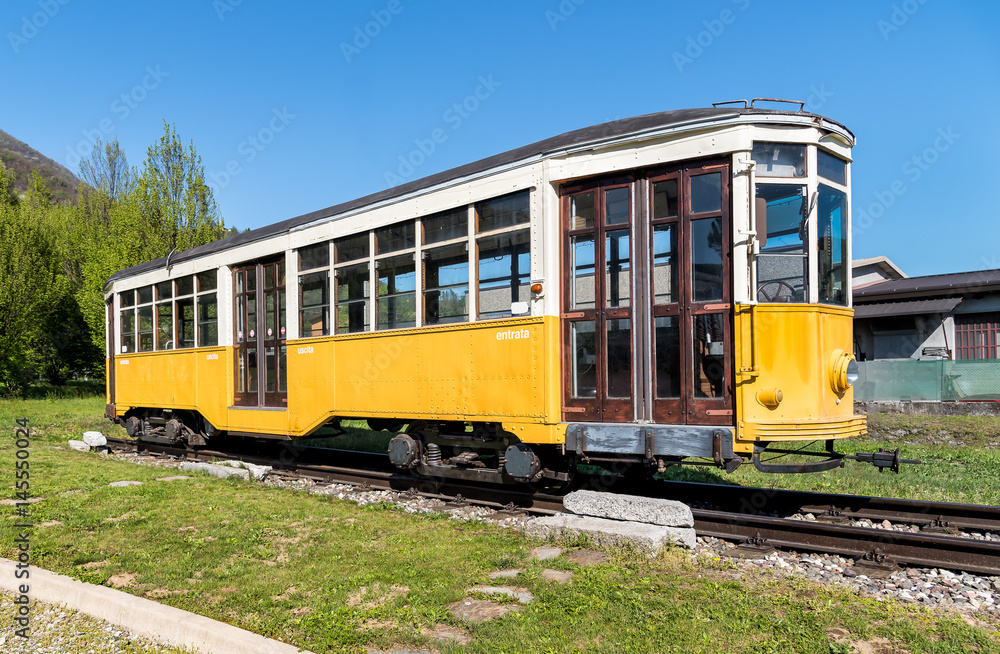 Yellow vintage tram on tracks
