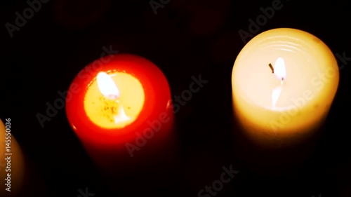 Three candles on table in empty dark room
