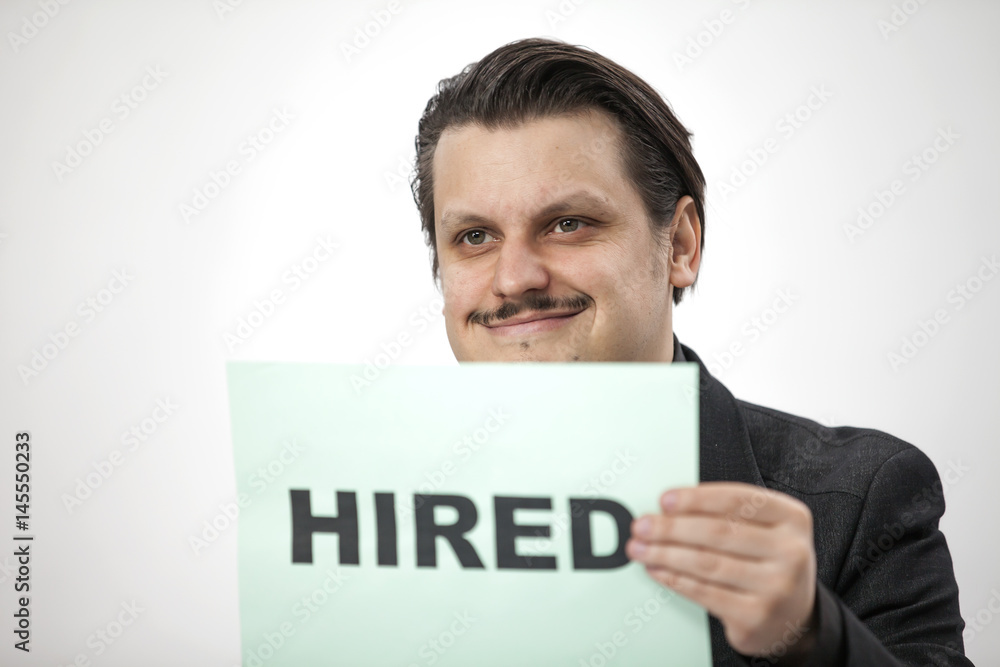 A businessman is smiling after being hired to a new job position. A businessman is smiling after being hired to a new job position.