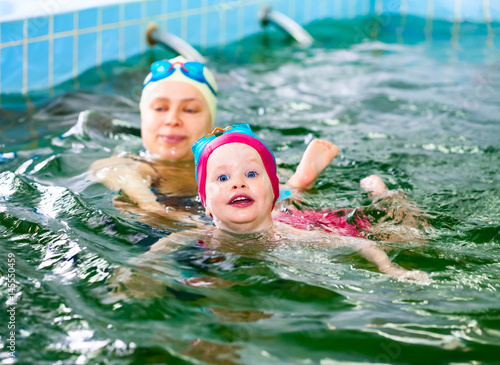 Little girl learning to swim with mother's help in a seawater swimming pool © Dmitry Naumov