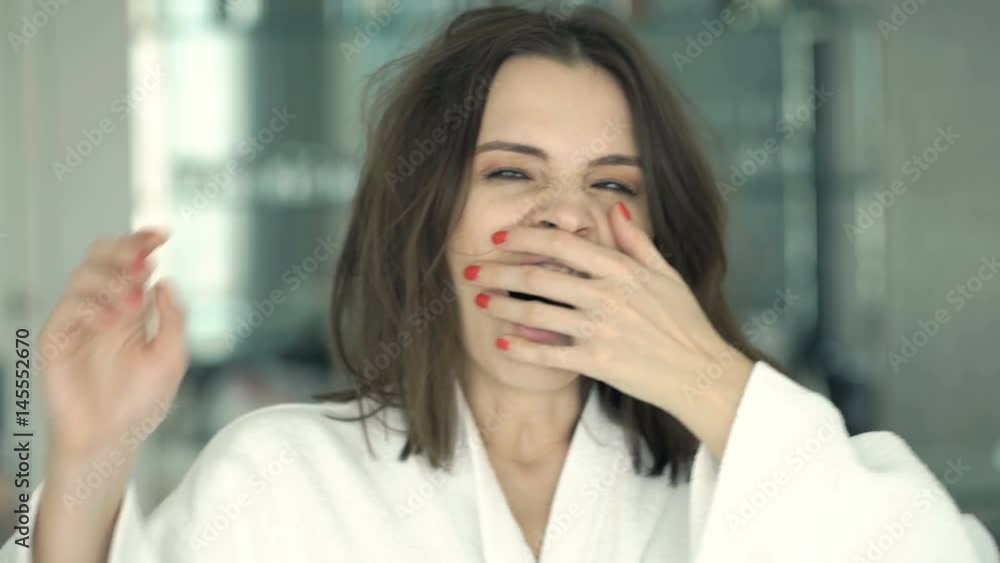 Portrait of sleepy woman in bathrobe yawning in front of mirror at home
Portrait of sleepy woman in bathrobe yawning in front of mirror at home