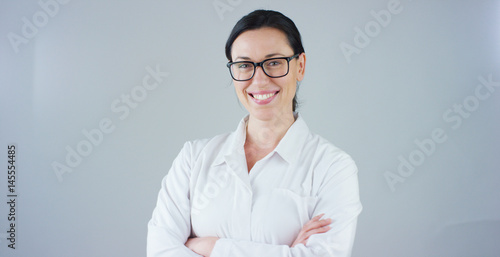 Portrait of a female doctor with white coat and stethoscope smiling looking into camera on white background. Concept: doctor, health care, love of medicine.