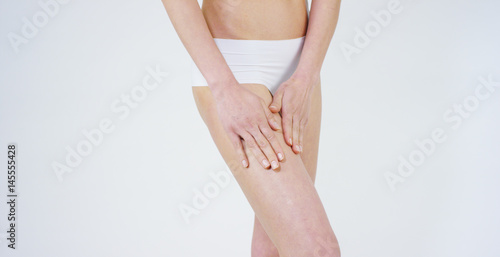 Beautiful legs of a young girl without cellulite, clean tender skin, good care, sports figure, on a white background. Concept: anti cellulite, proper nutrition,spa procedures,healthy lifestyle,jogging