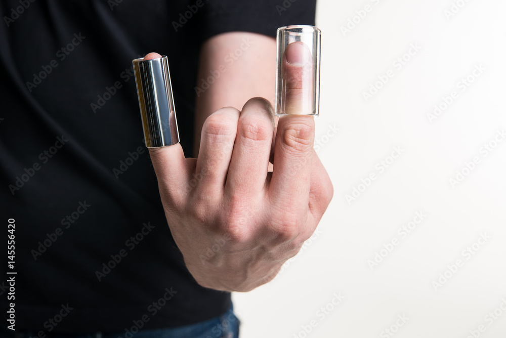 Fototapeta premium The guitarist's hand with two guitar sliders on his fingers. Horizontal frame