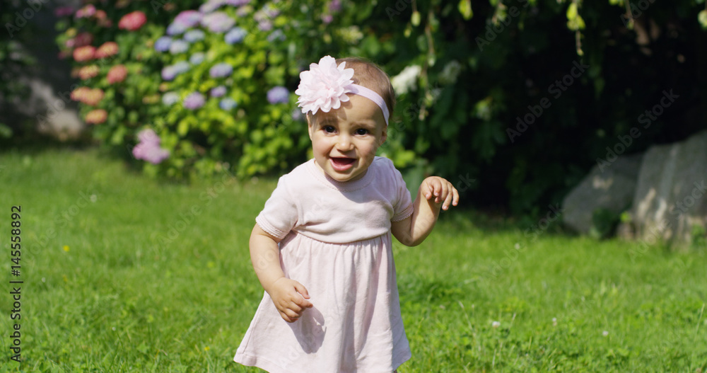 On a sunny spring day a little girl dressed like a ballet dancer spinning around in the garden herself and smiling happily	