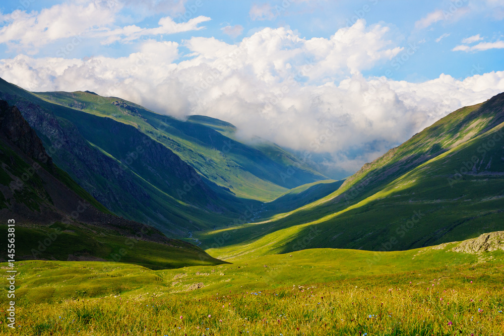 A beautiful view of the mountains of the Caucasus. The clouds in the blue sky. A beautiful view of the mountains of the Caucasus. The clouds in the blue sky.