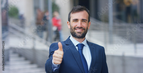 A man in a suit, looks in camera and smiles proud and sure of himself. Concept of politics, business, finance, banking, insurance and testimonials for political campaign.	