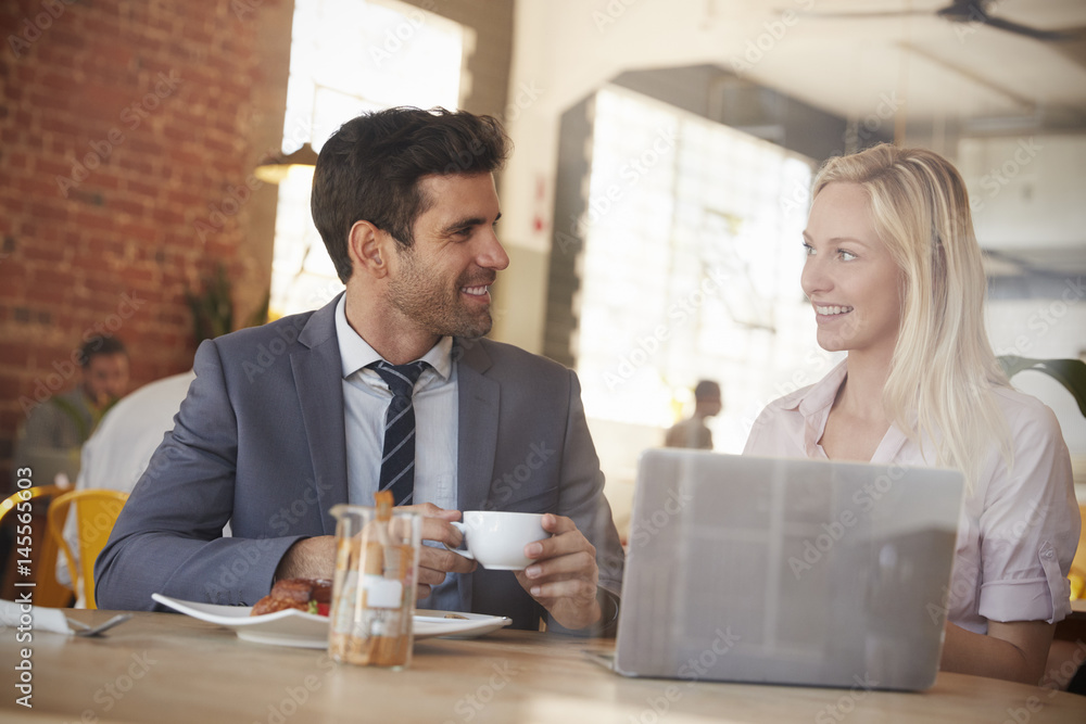Two Businesspeople Meet In Coffee Shop Shot Through Window Two Businesspeople Meet In Coffee Shop Shot Through Window