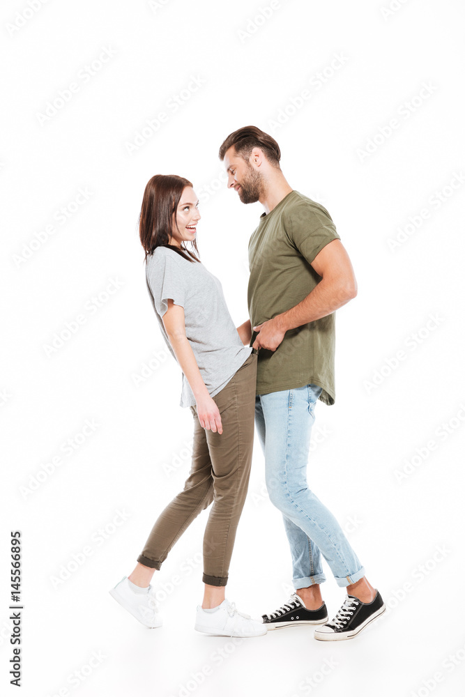 Happy young loving couple standing isolated