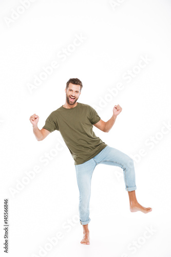 Happy young man standing isolated over white background