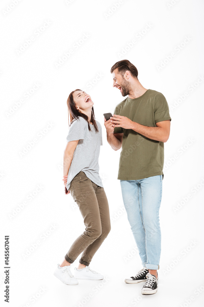 Laughing young loving couple holding phones. Laughing young loving couple holding phones.