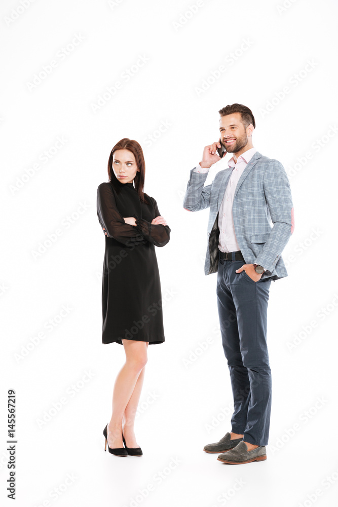 Sad woman looking aside while man talking by phone Sad woman looking aside while man talking by phone
