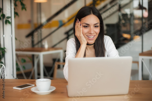 Woman in love drinks coffee and chat on laptop computer