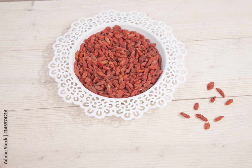 Dried goji berries in white bowl on wooden background Dried goji berries in white bowl on wooden background