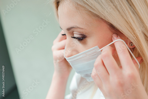 adult dentist puts a protective mask on her mouth