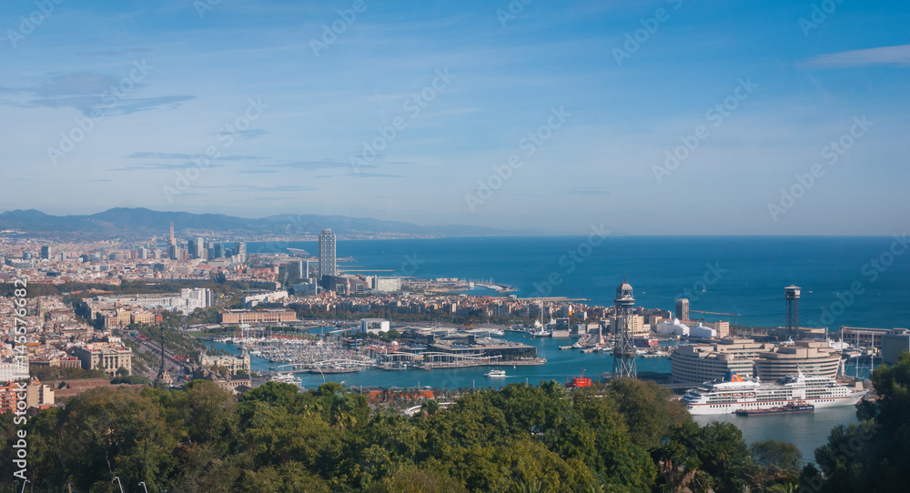 Beautiful Blue commerce.  Coastline of Spain in seaside Barcelona.  Modern city scape & coastline as seen from high level, cable car over the city. 