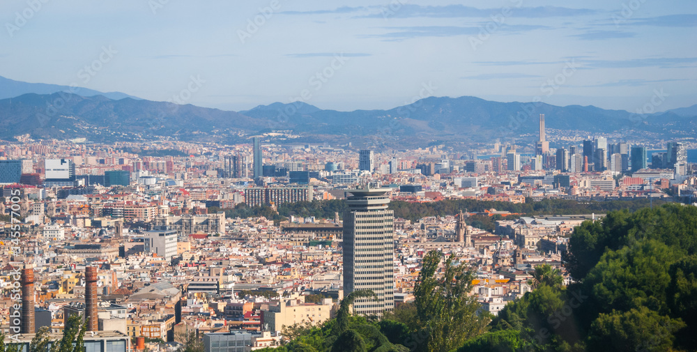 Barcelona cityscape view from high a level, cable car as it passes over tree tops providing views of the city. 