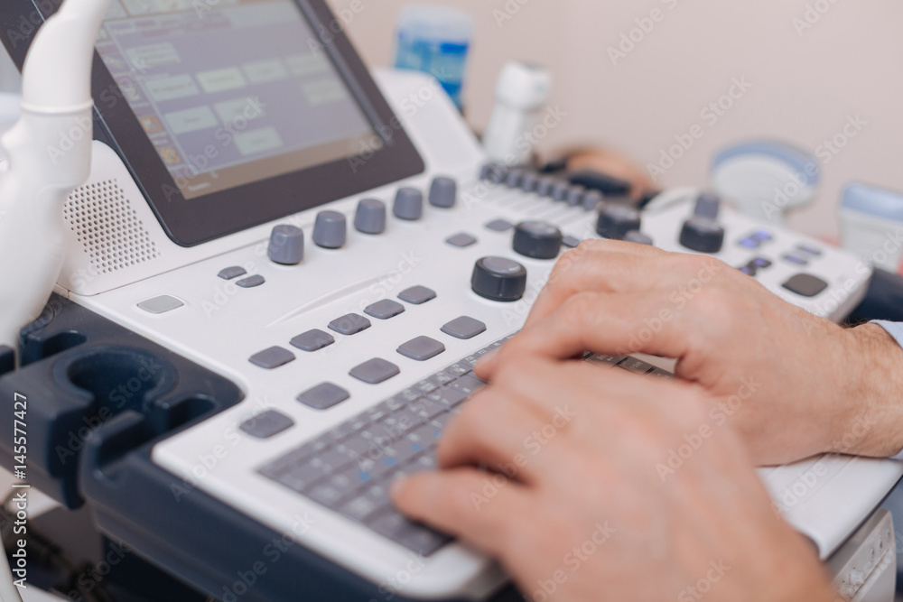 Skillful sonographer using professional equipment in the clinic Skillful sonographer using professional equipment in the clinic
