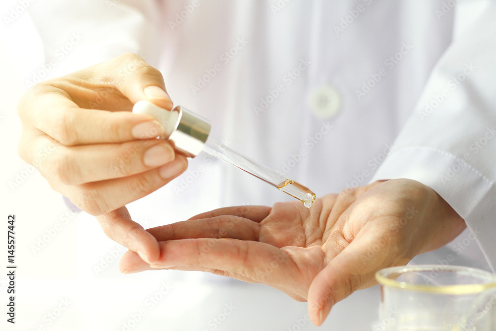 Beauty cosmetics sciences, Formulating and mixing skincare with herbal essence, Scientist testing a new organic beauty products on hand. Beauty cosmetics sciences, Formulating and mixing skincare with herbal essence, Scientist testing a new organic beauty products on hand.