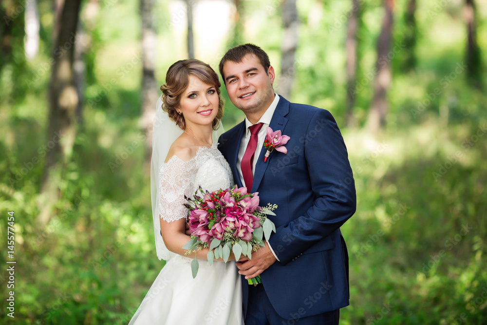 Portrait of happy bride and groom in park at wedding day Portrait of happy bride and groom in park at wedding day