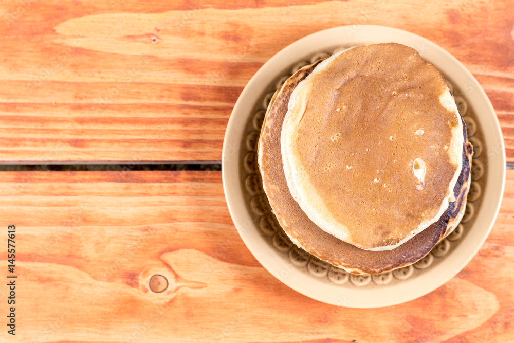 American pancakes on the plate over rustic wooden background table American pancakes on the plate over rustic wooden background table