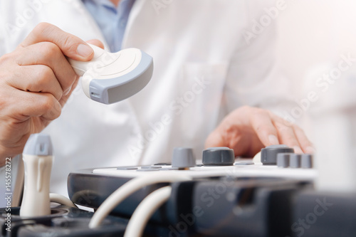 Attentive medic testing sonogram equipment in the clinic