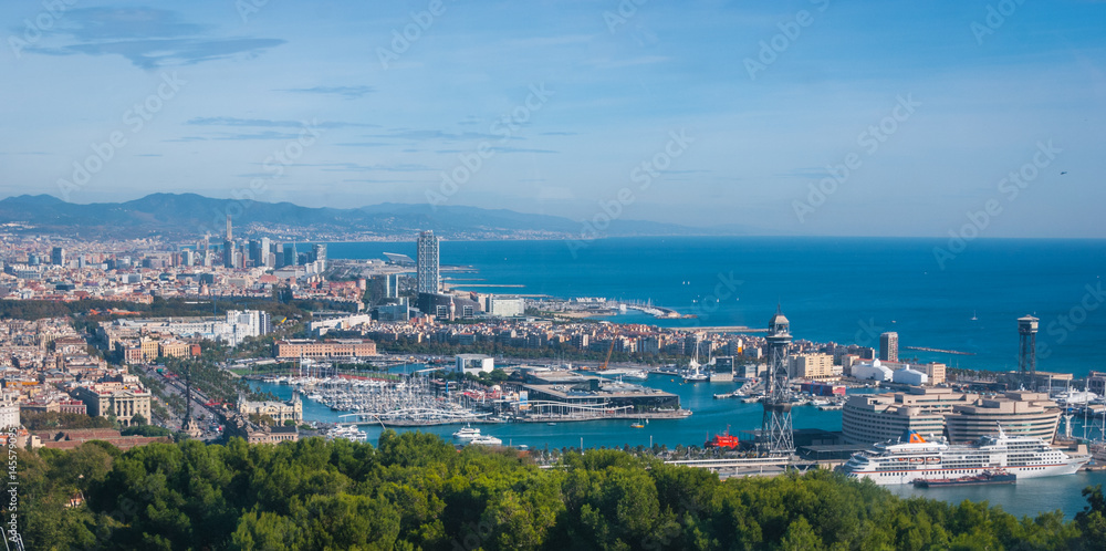 Beautiful Blue commerce.  Coastline of Spain in seaside Barcelona.  Modern city scape & coastline as seen from high level, cable car over the city. 