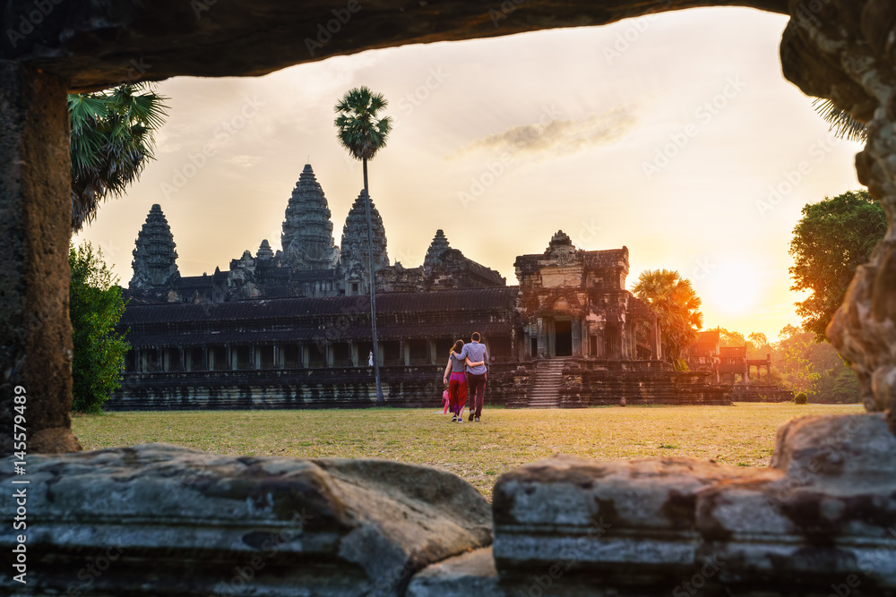 Naklejka premium Travel couple in Angkor Wat at sunrise moment, Siem Reap, Cambodia