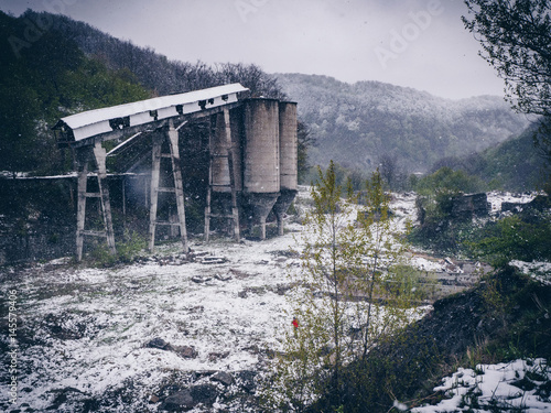 Post-industrial landscape of the abandoned mining facility in Anina, Romania in winter time (snowing) photo