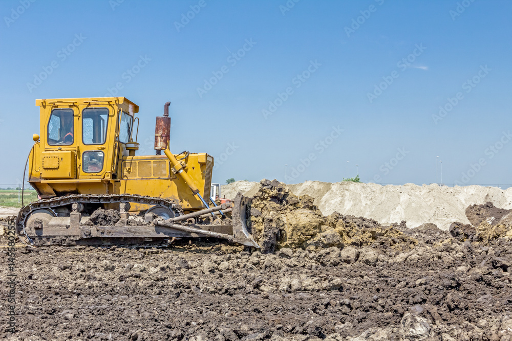 Heavy earthmover construction machine is moving earth at building site Heavy earthmover construction machine is moving earth at building site