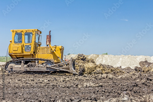 Heavy earthmover construction machine is moving earth at building site